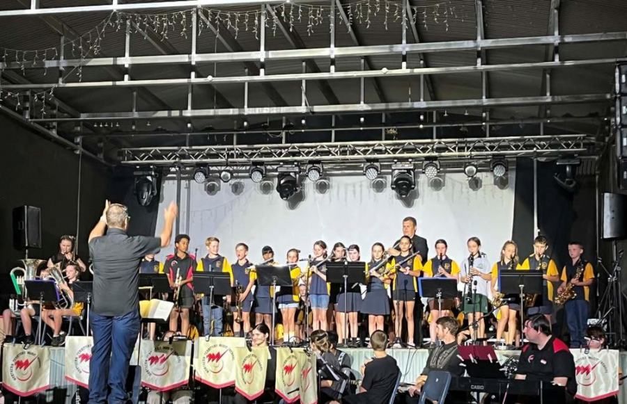 A man is leading a band on a stage.