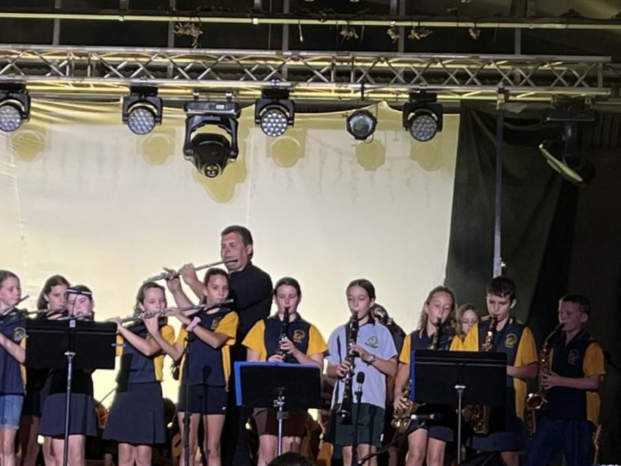 A group of children are playing instruments on a stage