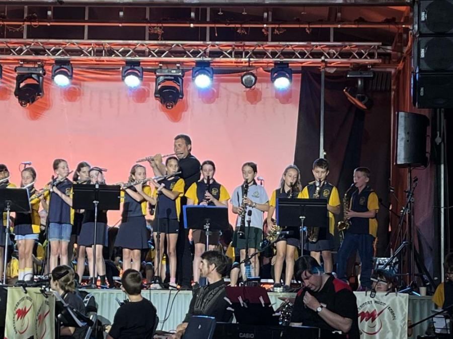 A group of young people are playing instruments on a stage.