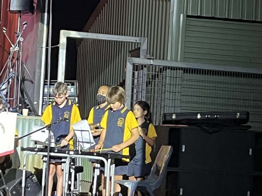 A group of children are playing instruments on a stage.