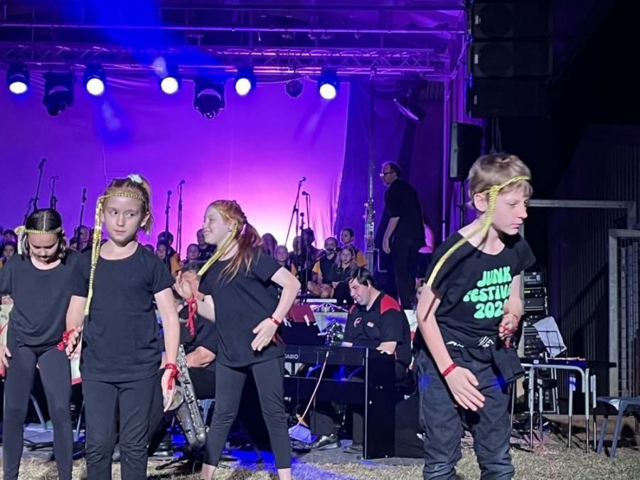 A group of children are dancing on a stage.