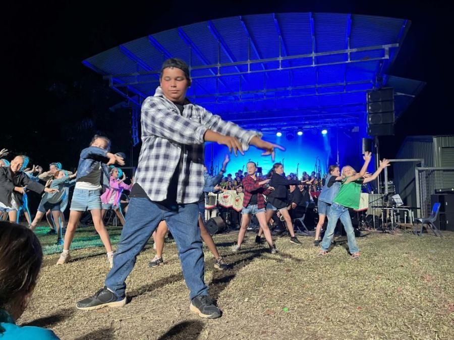A group of people are dancing on a stage at a concert.