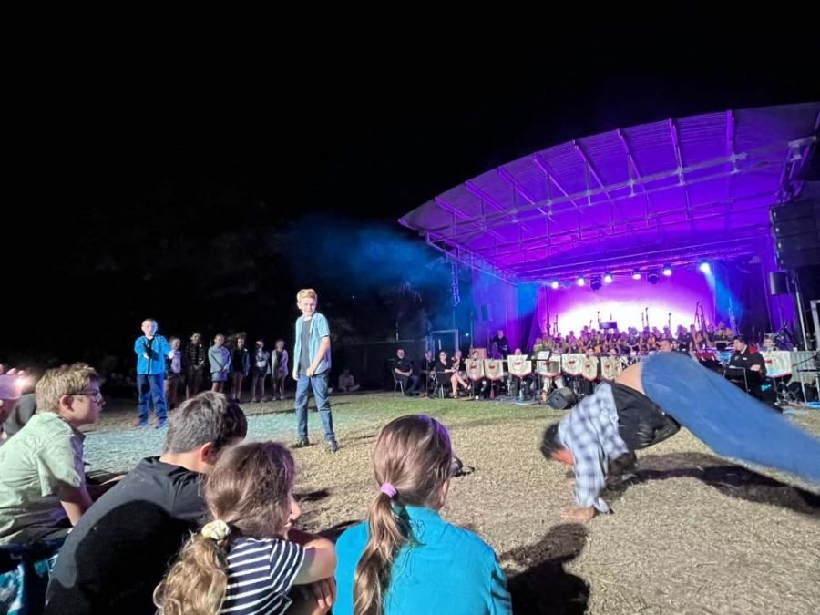 A group of people are sitting in front of a stage at a concert.