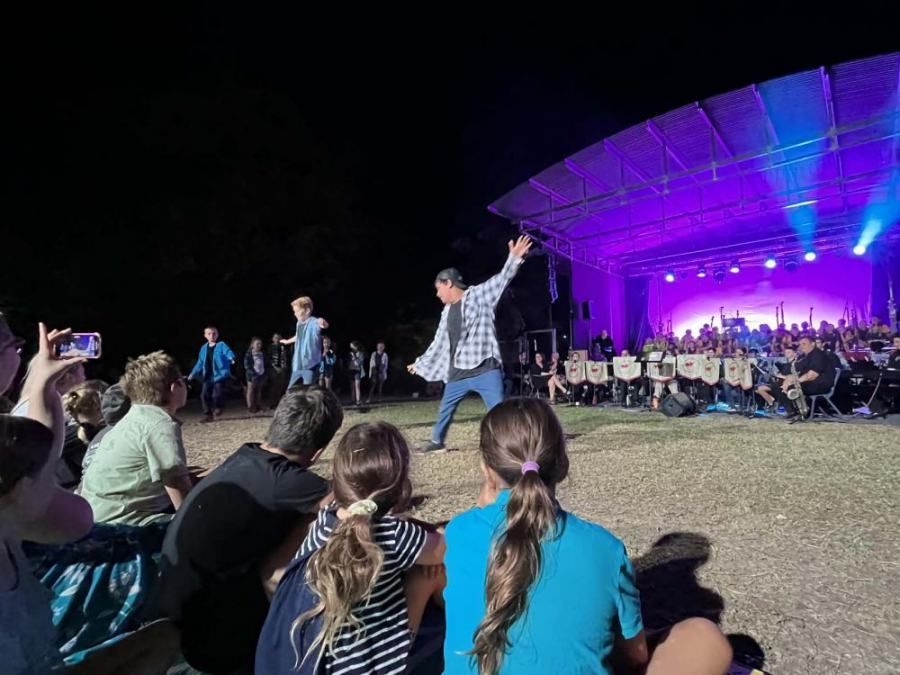 A group of people are sitting in front of a stage at a concert.