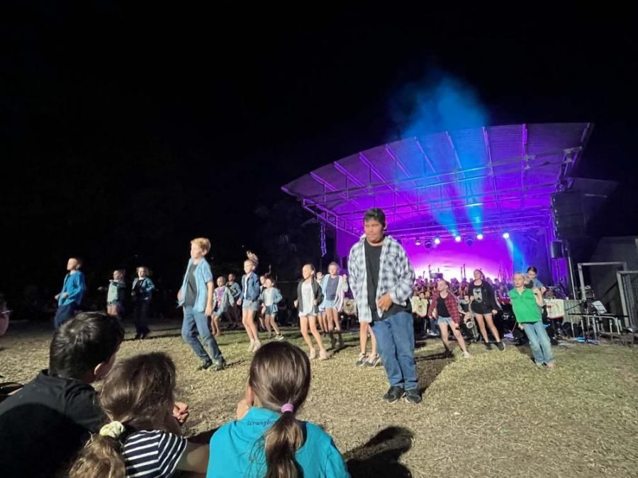 A group of people are dancing on a stage at a concert.