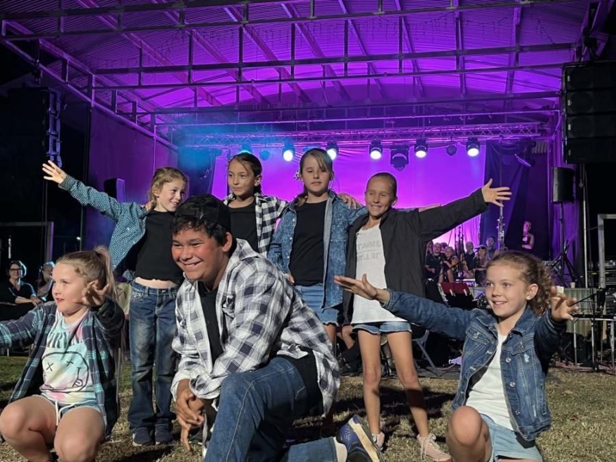 A group of young people are dancing on a stage.