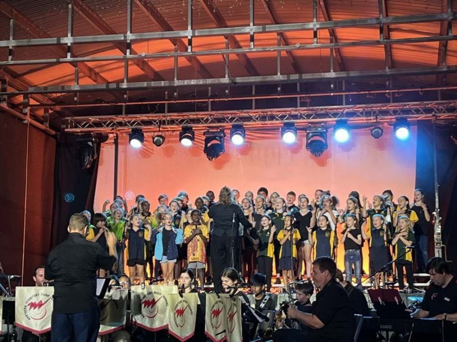 A large group of people are singing on a stage