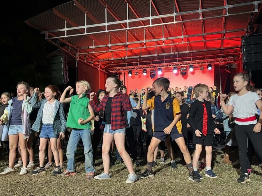 A group of children are dancing on a stage.