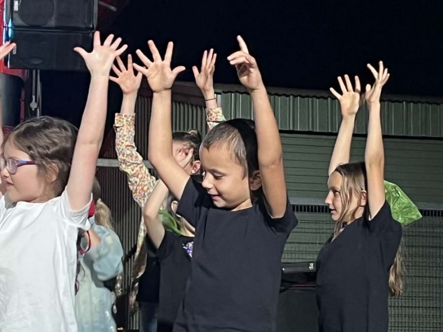 A group of young girls are raising their hands in the air