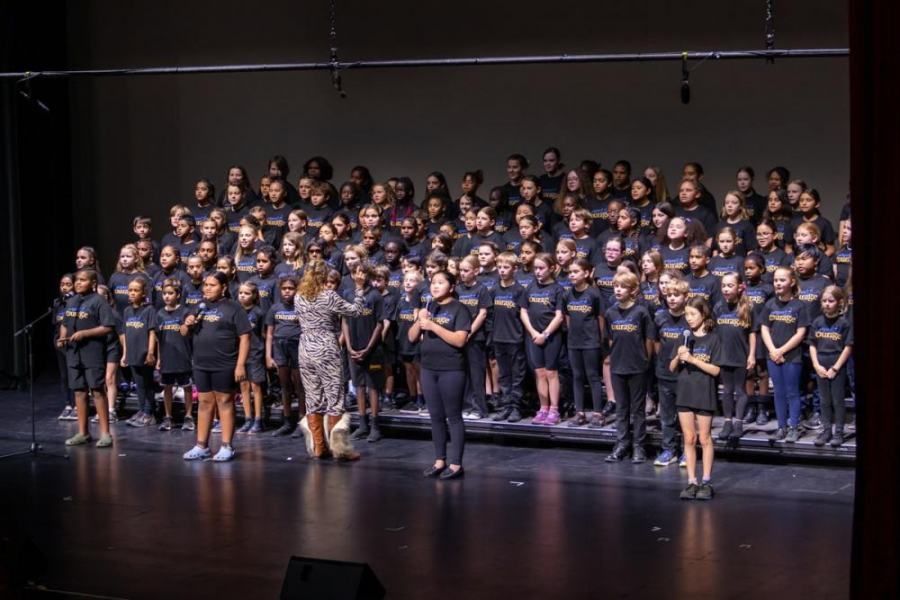 A large group of children are standing on a stage.