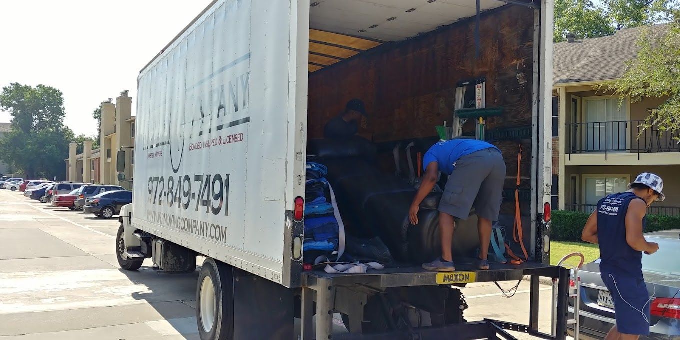 A man is standing next to a moving truck.
