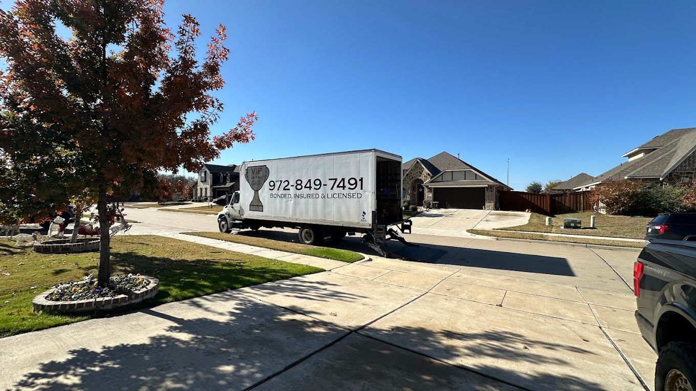 A moving truck is parked in the driveway of a house.
