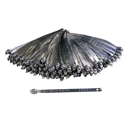 Metal security seals, silver color, with stamped serial numbers and a ball-shaped locking mechanism, piled and individually.