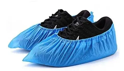 Blue shoe covers over black athletic shoes.