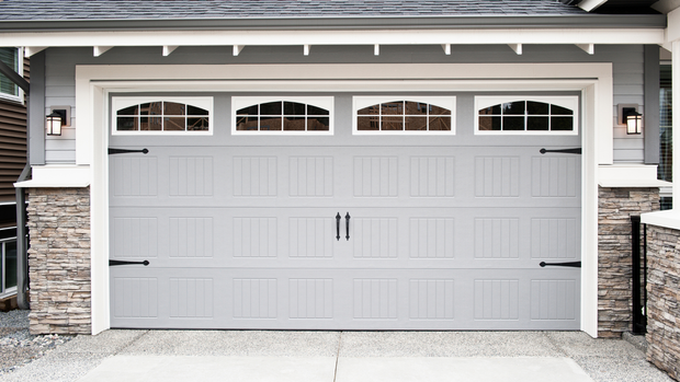 Gray garage door with arched windows and black hardware.