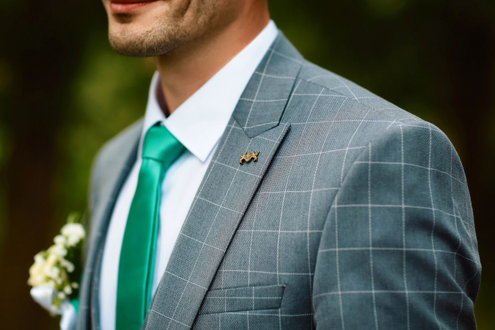 A Man in A Suit and Green Tie Is Standing in The Woods — New Park Suit Hire & Menswear in Cairns, QLD