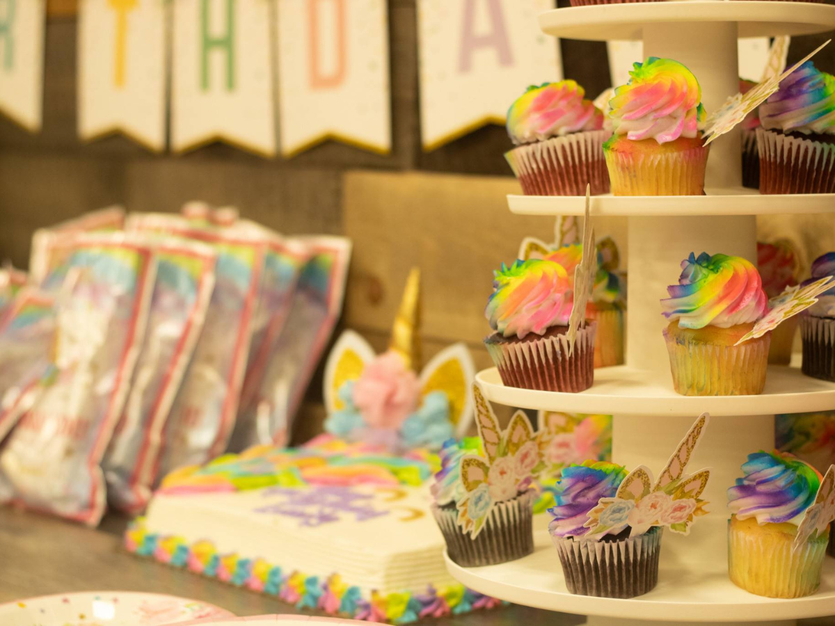 A cupcake tower filled with cupcakes decorated to look like unicorns.