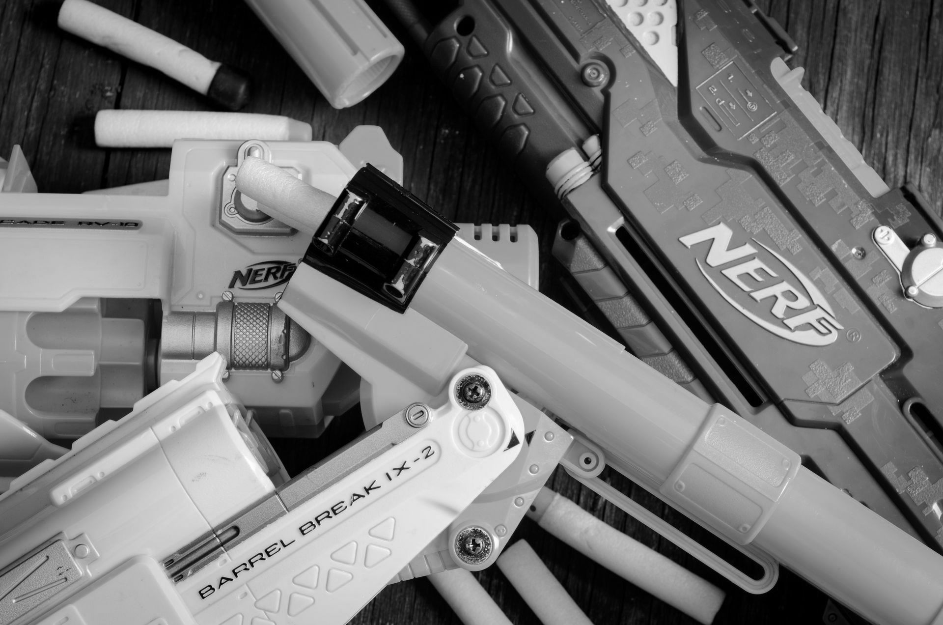 Nerf Guns in black and white laid on top of each other