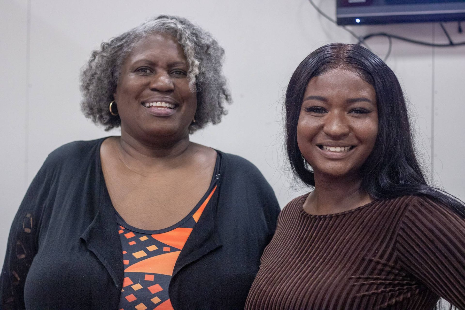 Two women are posing for a picture together and smiling for the camera at Impact Fun Zone