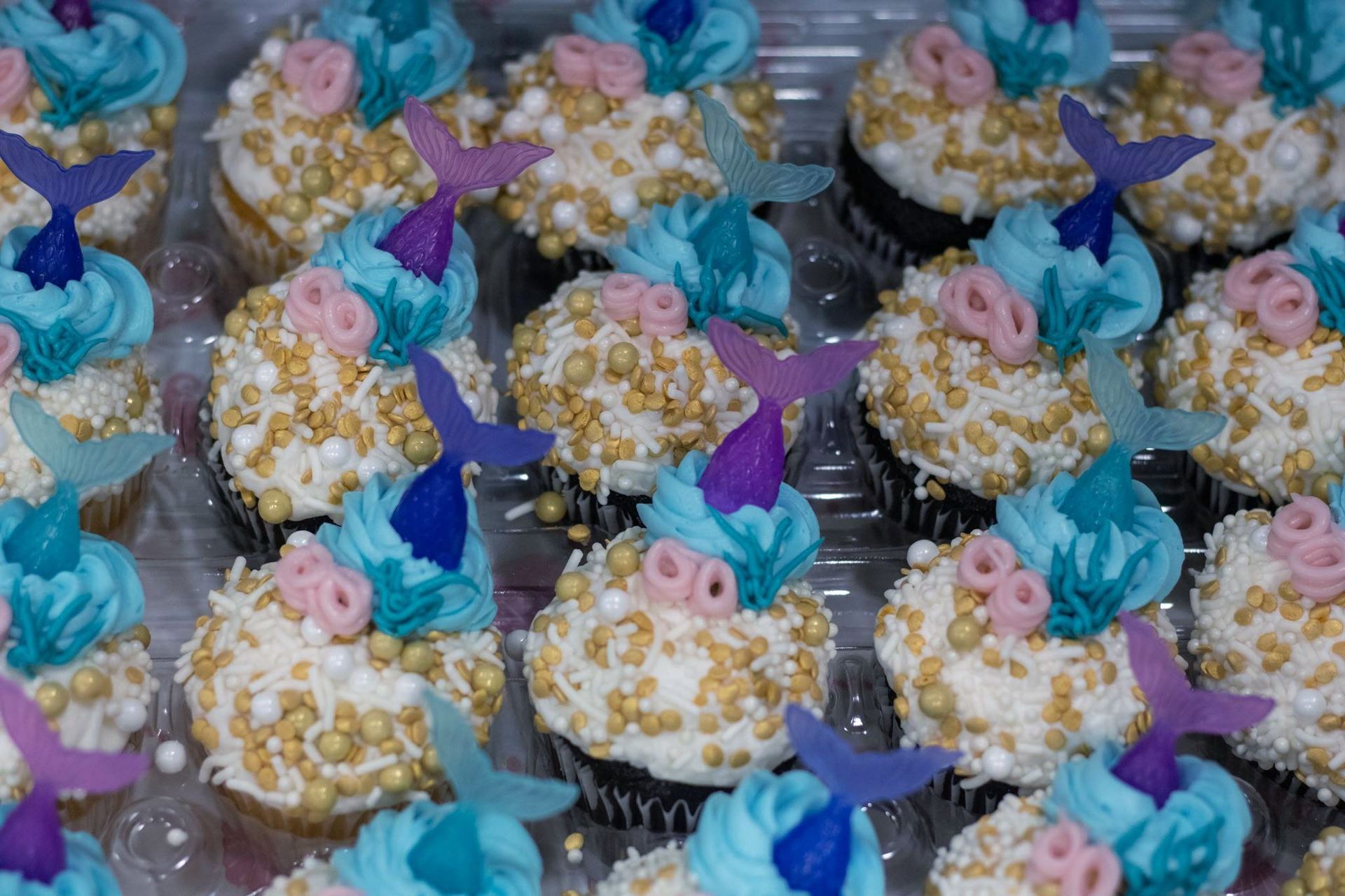 A bunch of cupcakes with mermaid tail decorations on them at Impact Fun Zone