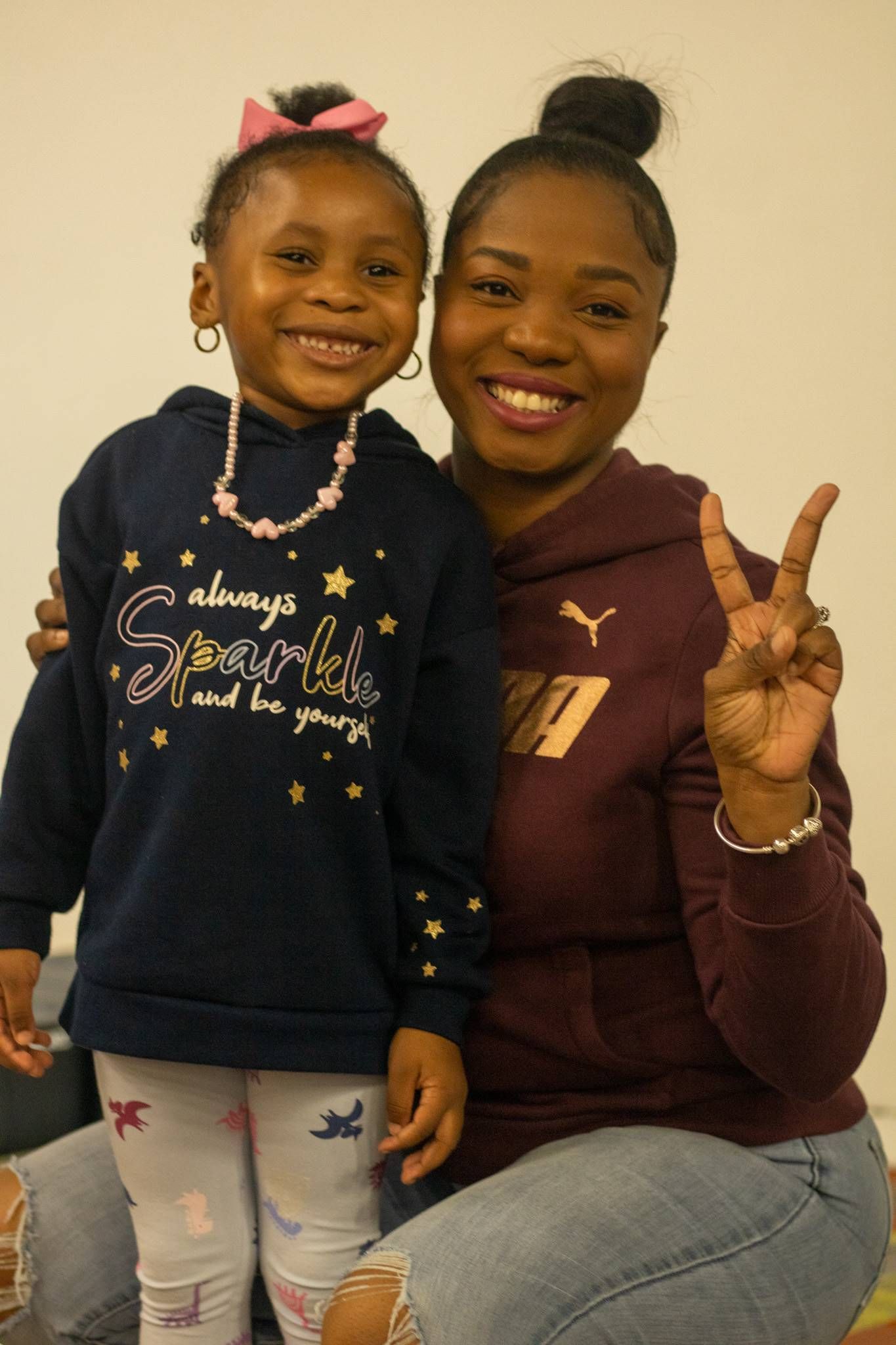 A woman and a little girl are posing for a picture at Impact Fun Zone