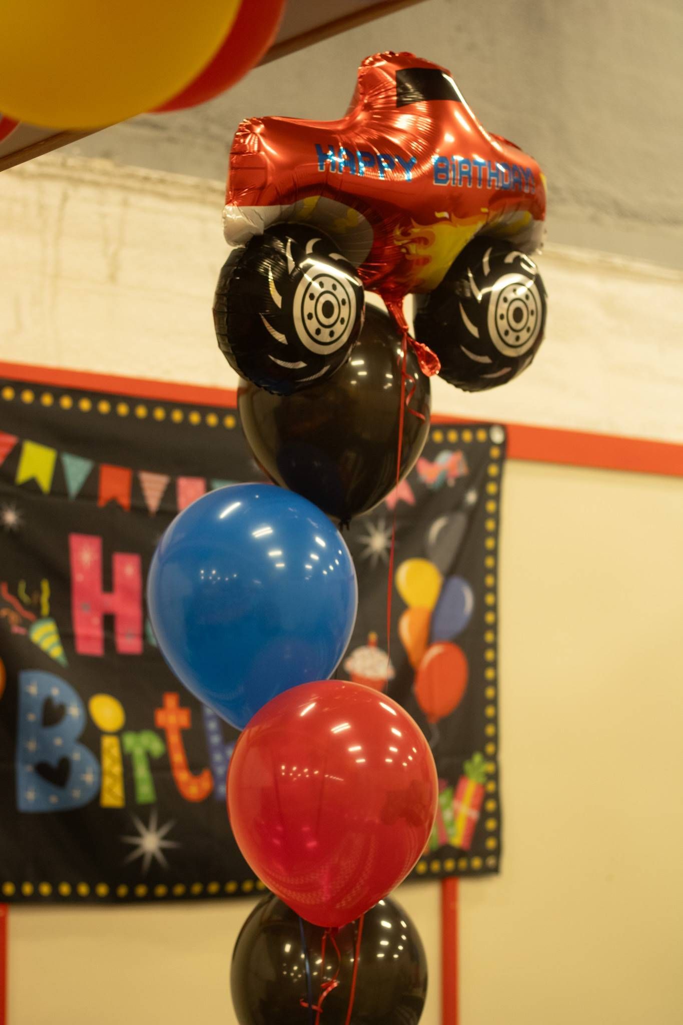 A bunch of balloons with a balloon in the shape of a monster truck at Impact Fun Zone
