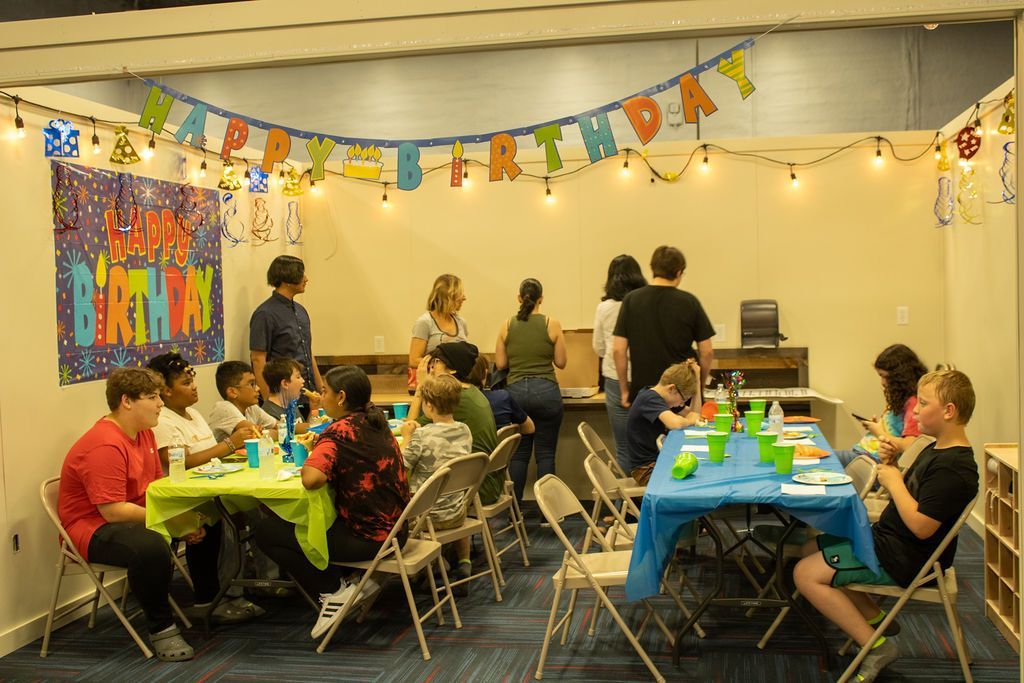 A group of kids sitting at tables at a birthday party at Impact Fun Zone