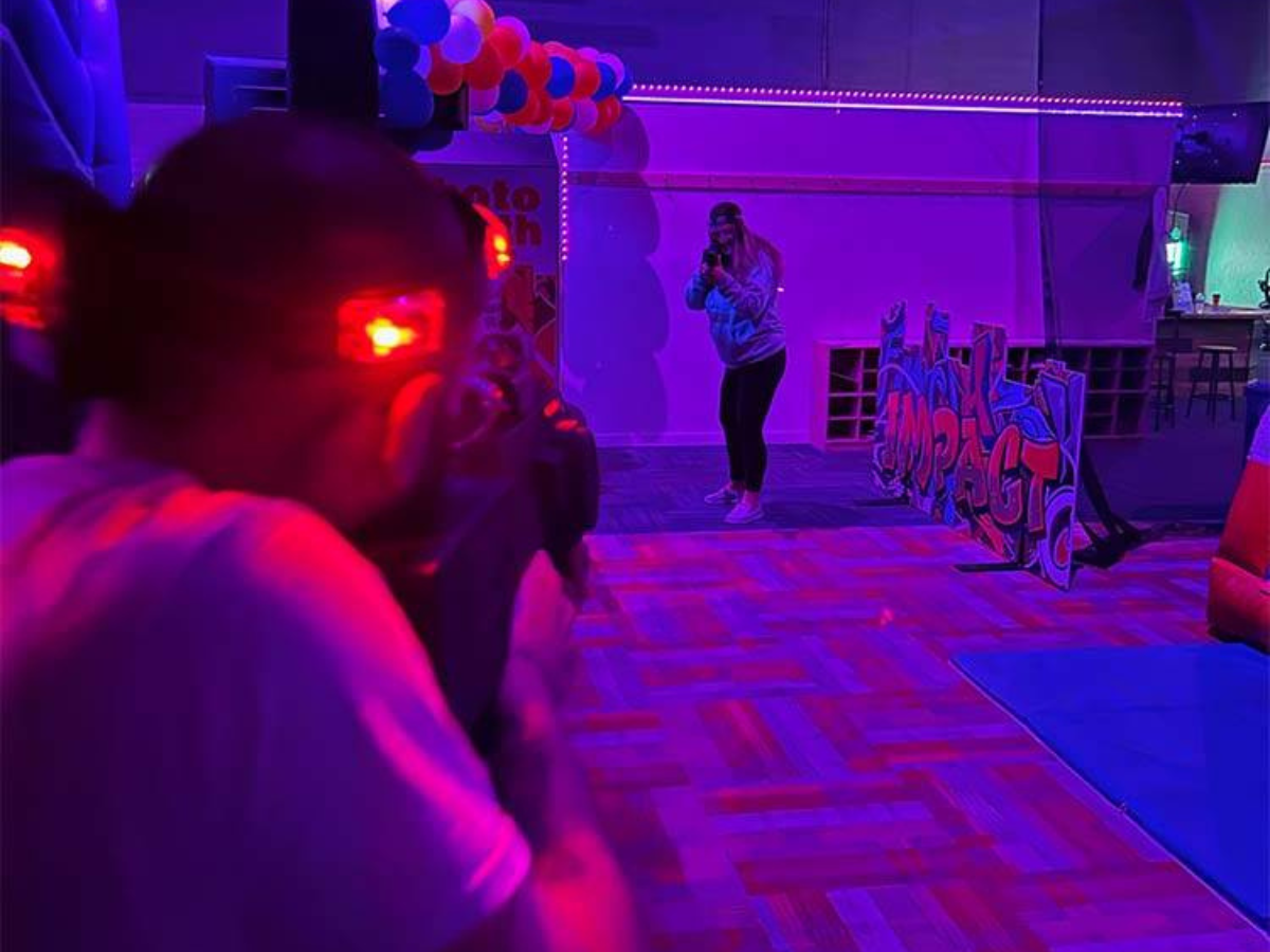 A person is playing a game of laser tag in a dark room.