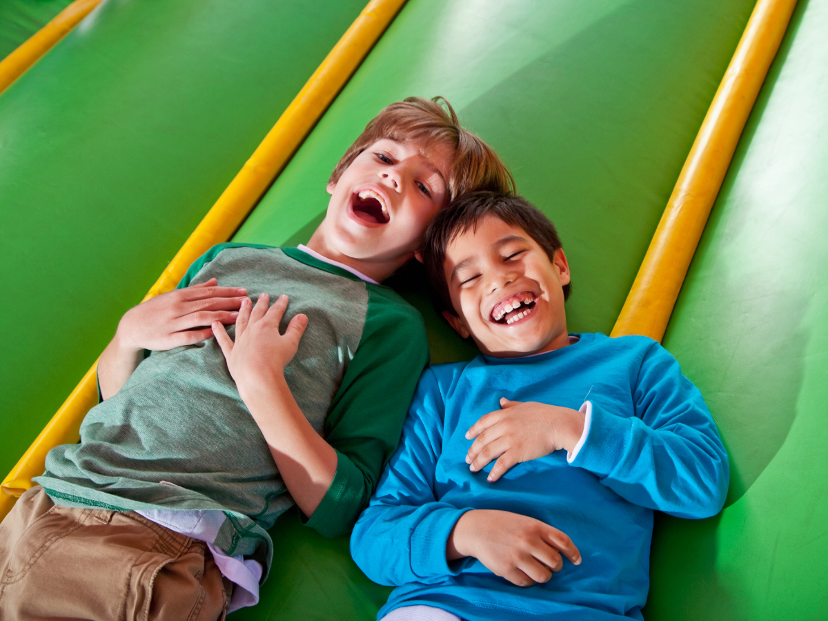 Tow kids laying on a indoor bounce space Tow kids laying on a indoor bounce space