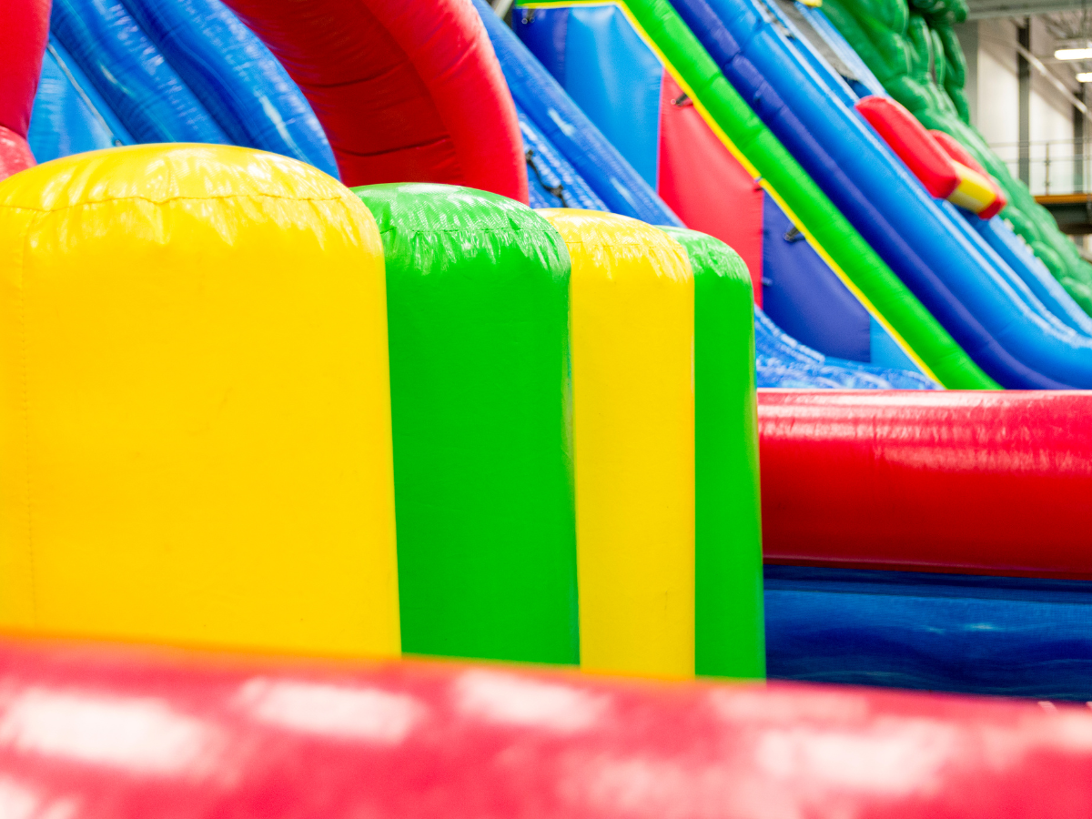 A bunch of colorful inflatable slides are lined up in a room.
