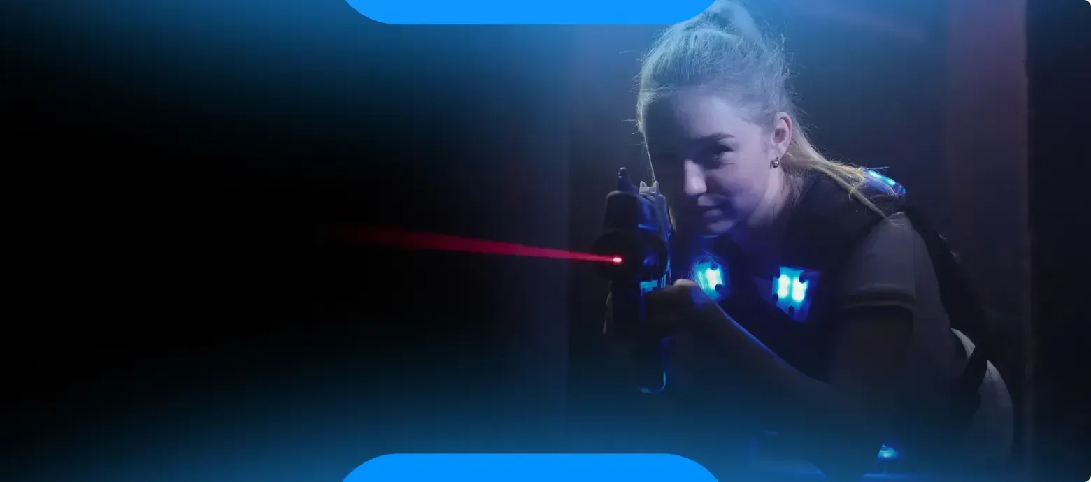 A woman is playing a game of laser tag in a dark room.