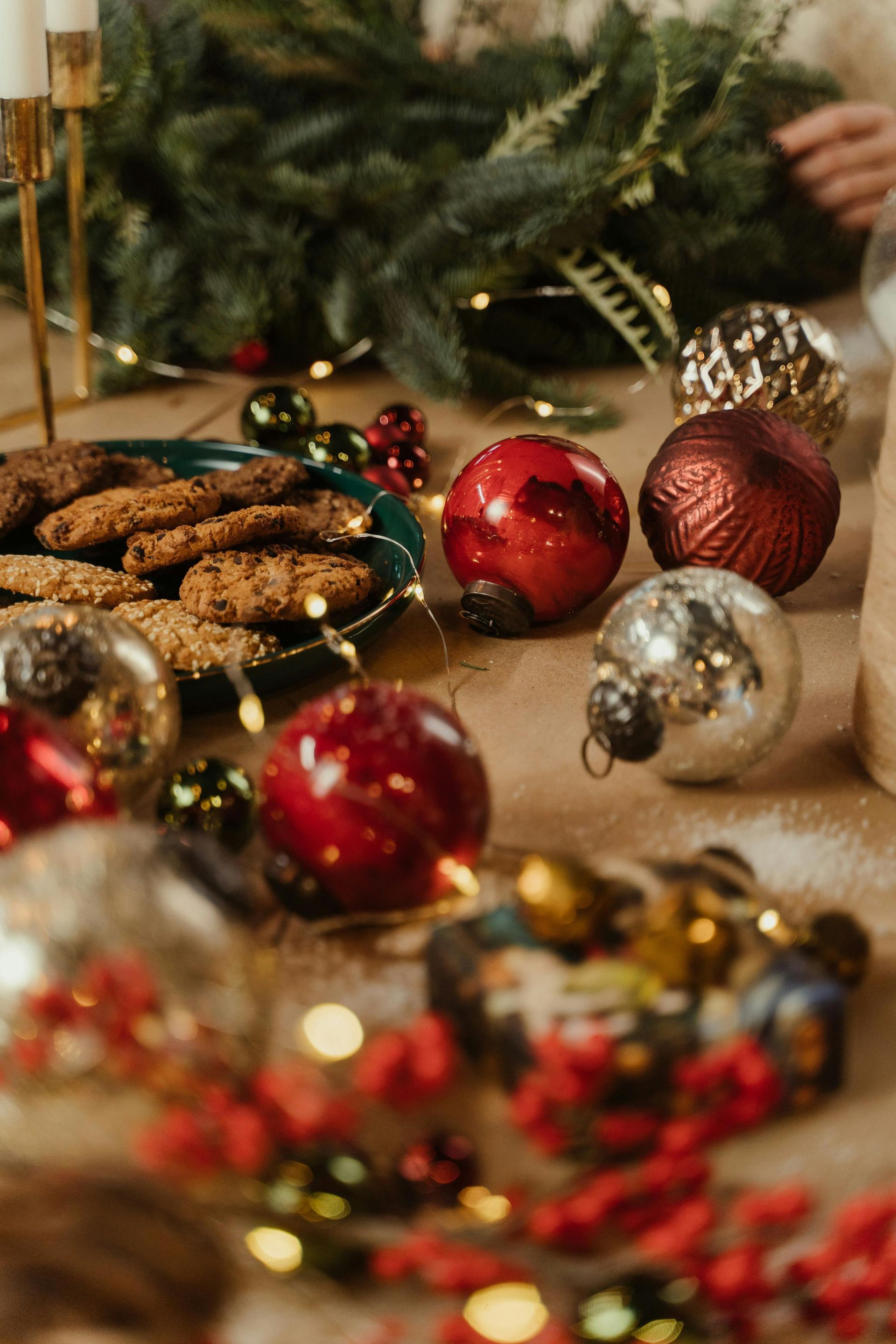 A table topped with christmas decorations and a plate of cookies.