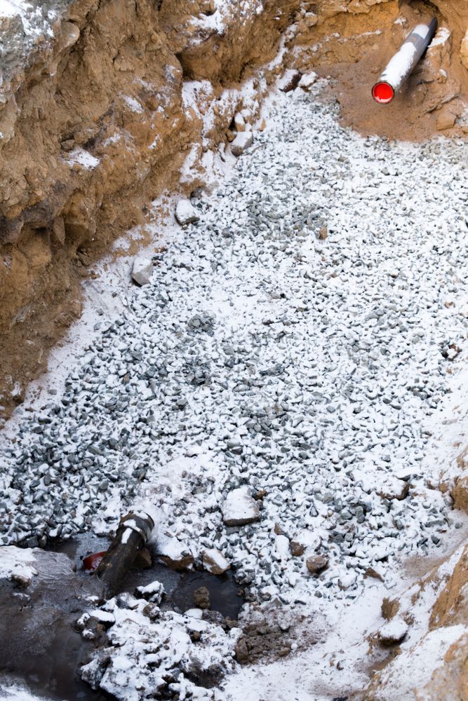 A Pile Of Rocks And Snow In A Hole With A Pipe — Hume Plumbing & Roofing Wollongong in Woonona, NSW