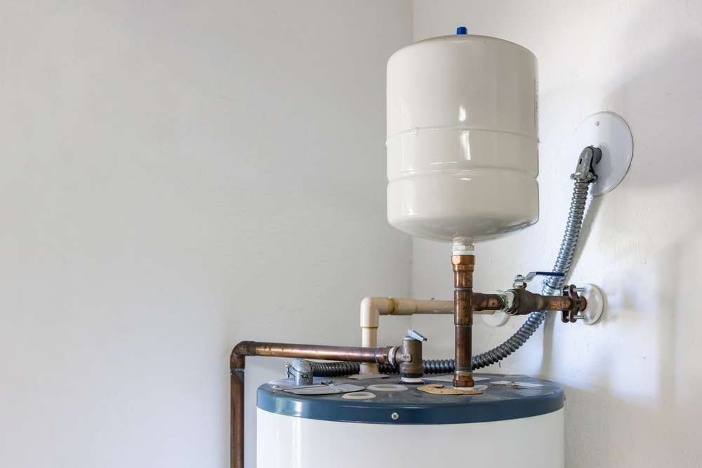 A Water Heater Is Attached To A Wall In A Room — Hume Plumbing & Roofing Wollongong in Woonona, NSW