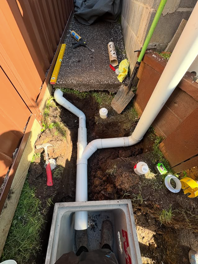 A Plumber Is Fixing A Sink With A Wrench — Hume Plumbing & Roofing Wollongong in Woonona, NSW
