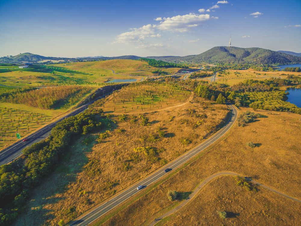 An Aerial View of a Highway Going Through a Lush Green Field — Hume Plumbing & Roofing Wollongong in Albion Park, NSW