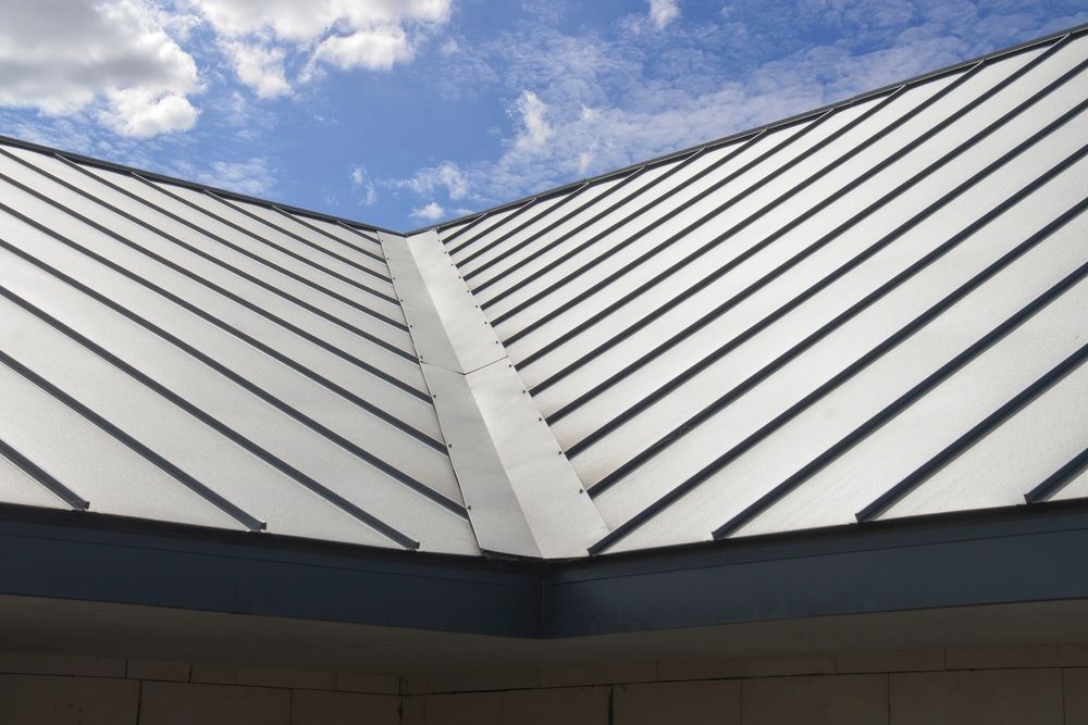 A Close Up of a Metal Roof With a Blue Sky in the Background — Hume Plumbing & Roofing Wollongong in Woonona, NSW