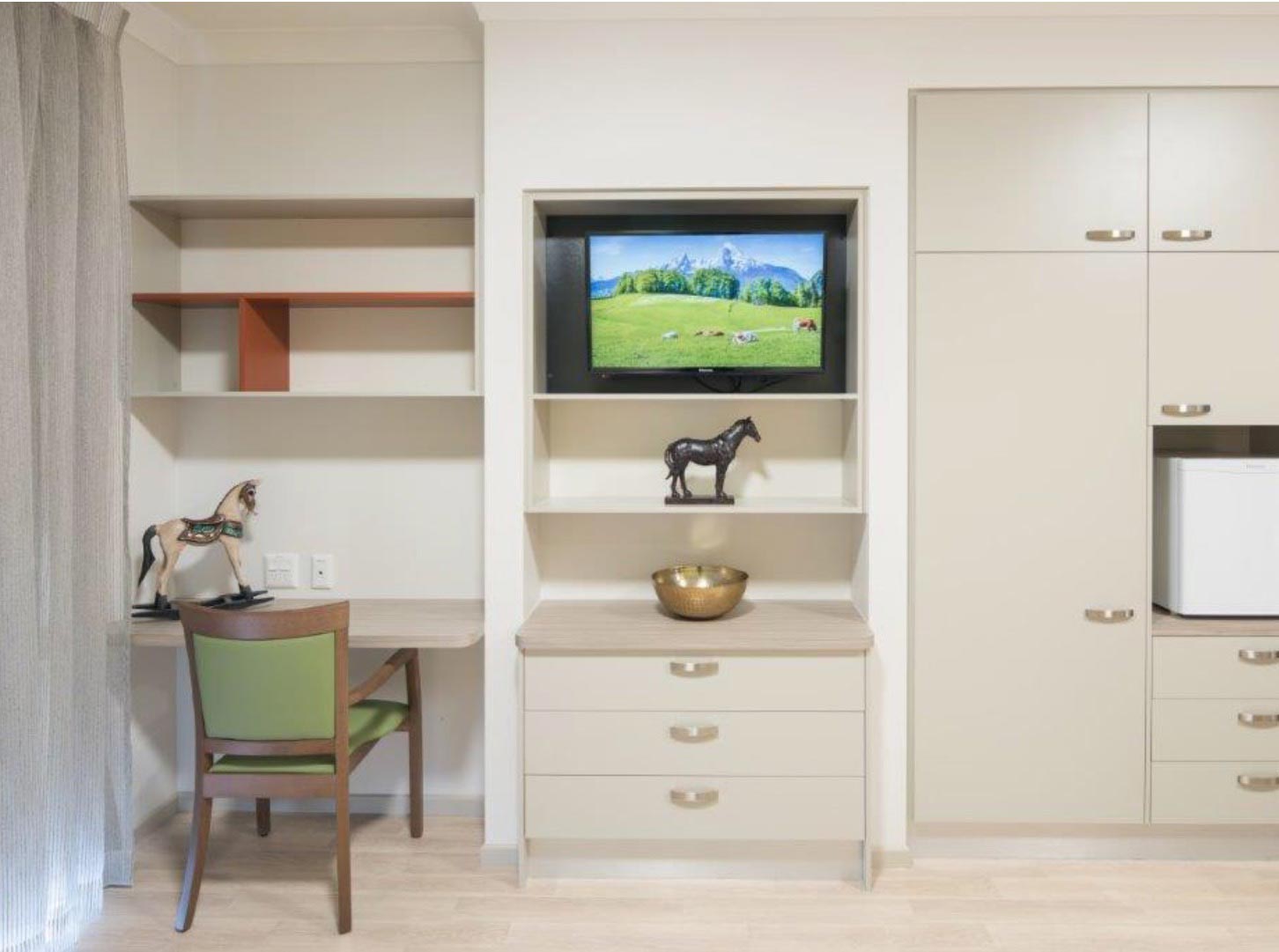 wall with drawers, a desk and a tv