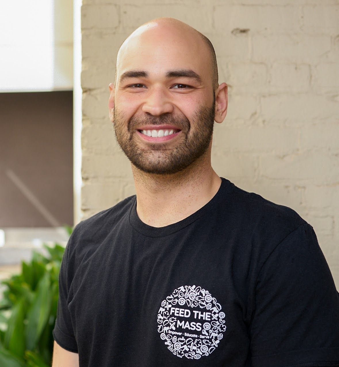 Bald man with a beard smiles, wearing a black 