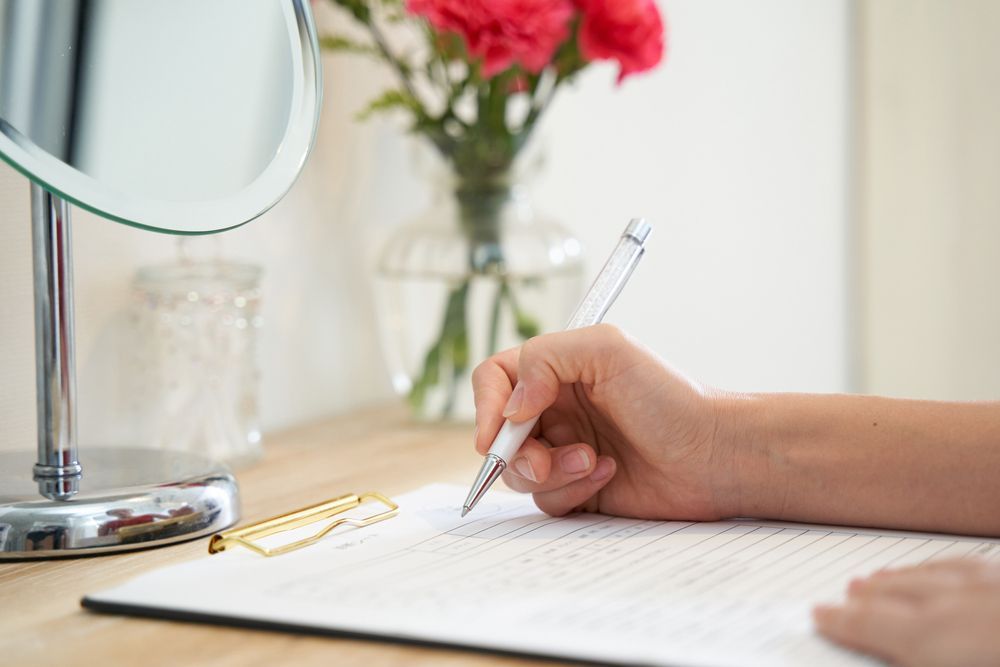 Hand Writing on Paper With a Pen — Bespoke Longevity and Aesthetic Medicine In Southport, QLD