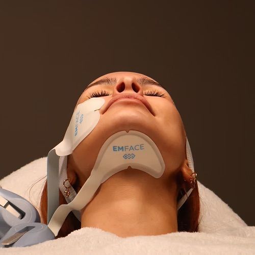 Woman with EMface Device on Face and Neck; Lying Down, Eyes Closed — Bespoke Institute In Southport, QLD