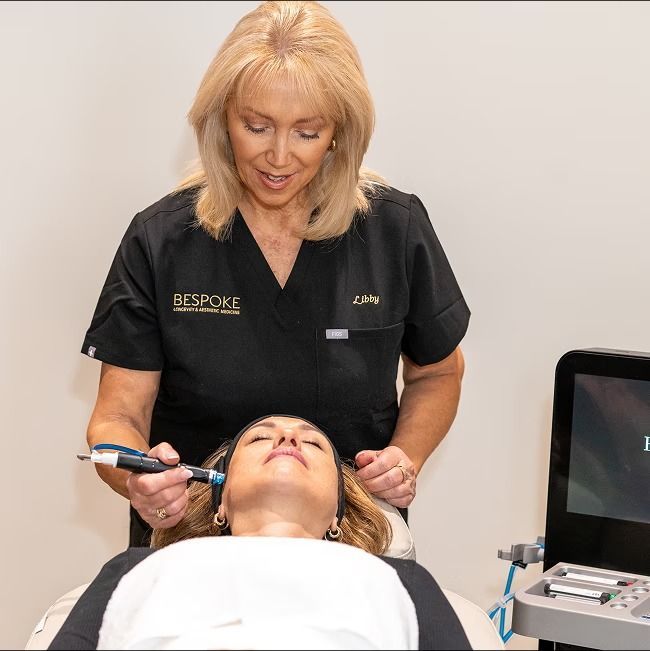 A Woman Wearing a Black Scrub Top That Says Bespoke on It — Bespoke Longevity and Aesthetic Medicine In Southport, QLD