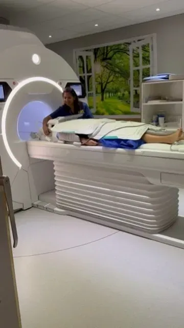 Person preparing patient for an MRI scan.
