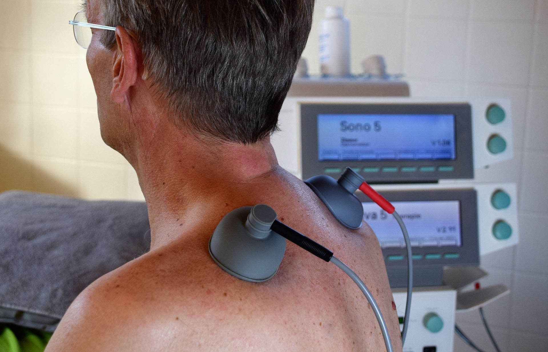 Man Receiving Therapy on His Shoulder With Electrodes — Bespoke Longevity and Aesthetic Medicine In Southport, QLD
