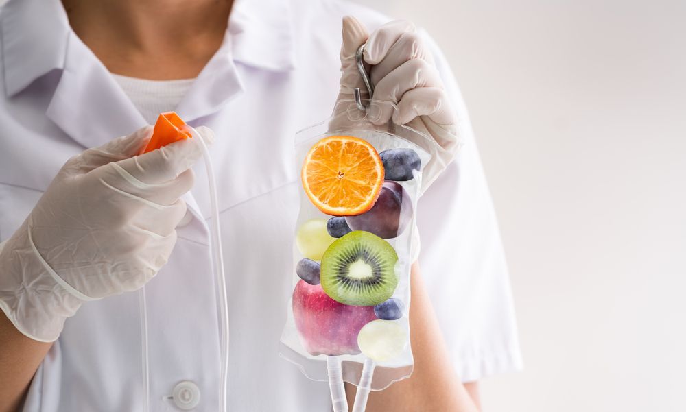 Nurse Holding IV Bag With Fruit Slices Inside — Bespoke Longevity and Aesthetic Medicine In Southport, QLD