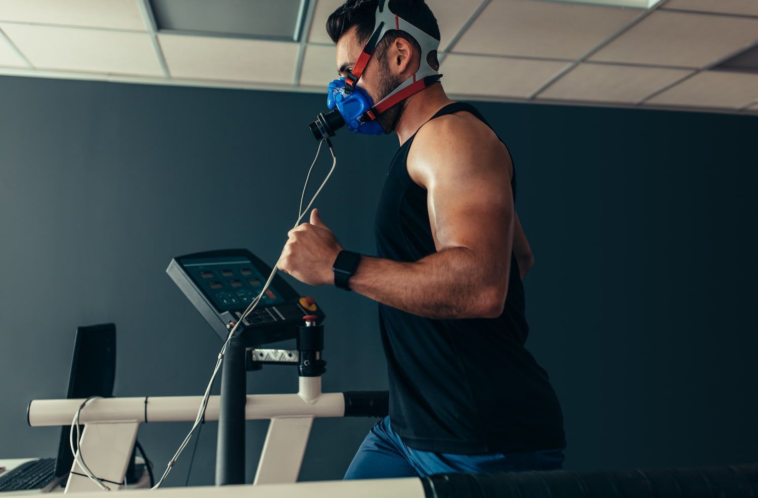 A Man is Running on a Treadmill With a Mask on His Face — Bespoke Institute In Southport, QLD