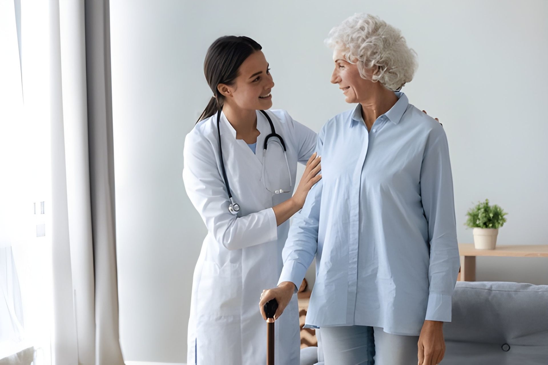 Doctor in White Coat Supports Elderly Woman — Bespoke Longevity and Aesthetic Medicine In Southport, QLD
