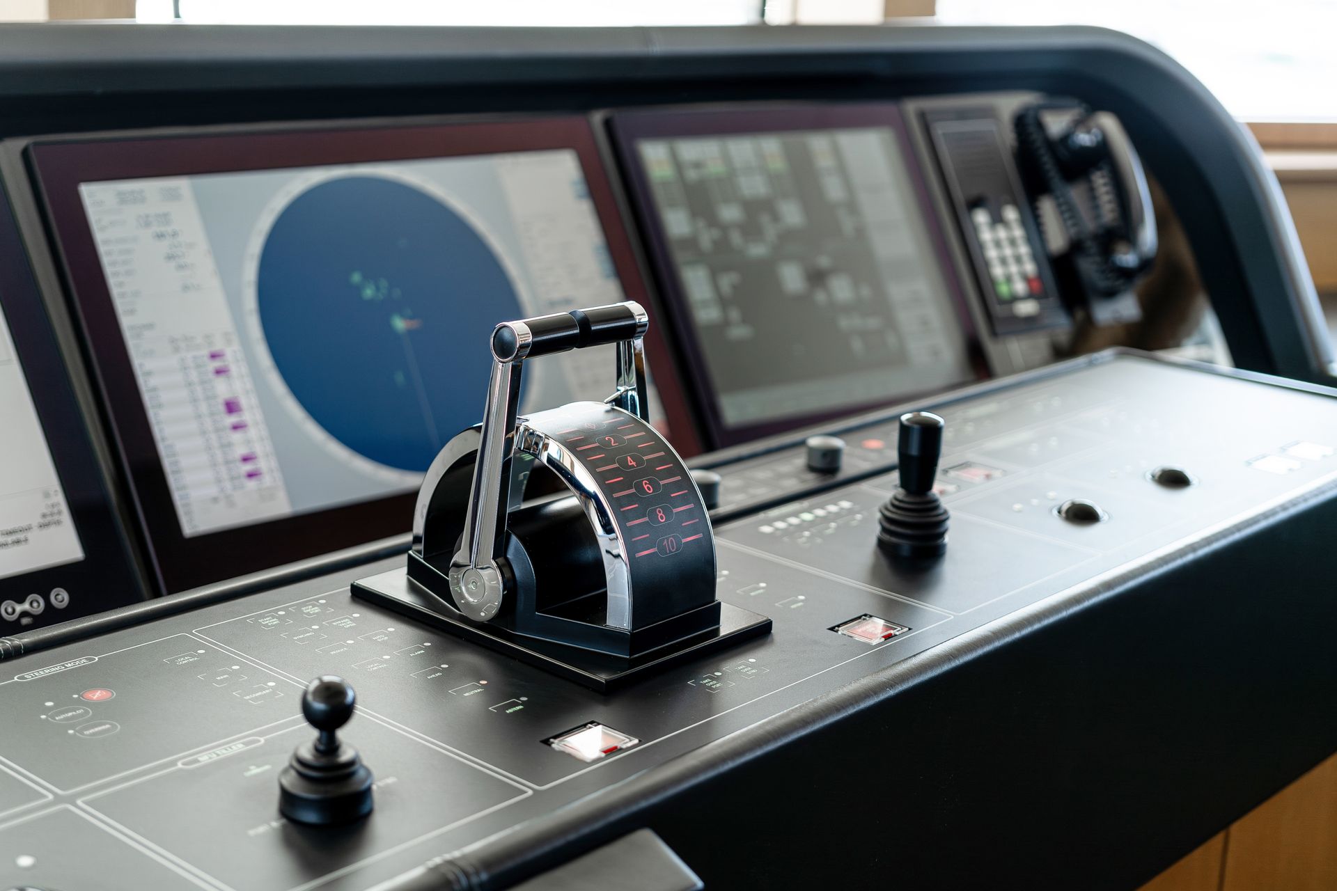 Ship bridge control console with radar screens and a throttle lever