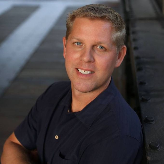 A man in a blue shirt is smiling for the camera