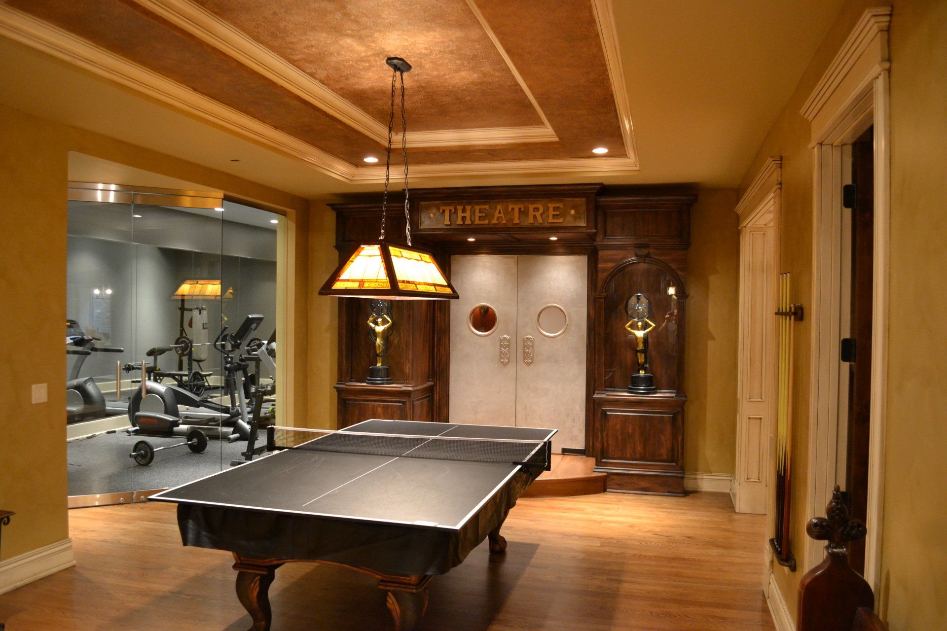Ping pong table in front of a theater, with a gym visible through a glass wall.